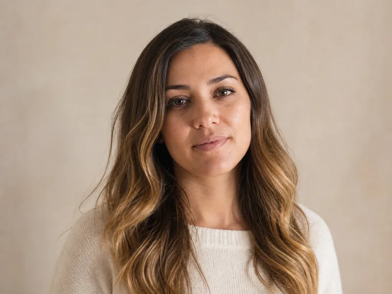 A woman whose hair transitions from brunette through copper to blonde